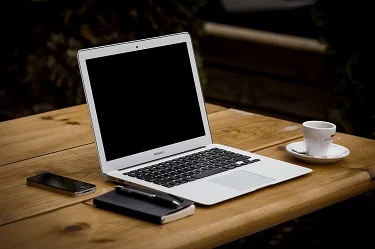 Stock photo of computer, phone, notepad, and teacup.
